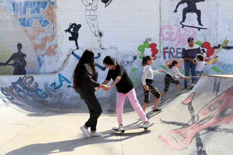 Palestinian girls practice on Skateboard sport at Gaza seaport, in Gaza city on October 27, 2021. A skateboard is a type of sports equipment used for skateboarding. They are usually made of a specially designed 7-8 ply m...