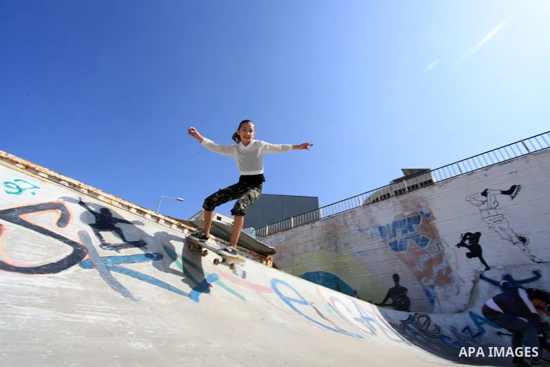 Palestinian girls practice on Skateboard sport at Gaza seaport, in Gaza city on October 27, 2021. A skateboard is a type of sports equipment used for skateboarding. They are usually made of a specially designed 7-8 ply m...