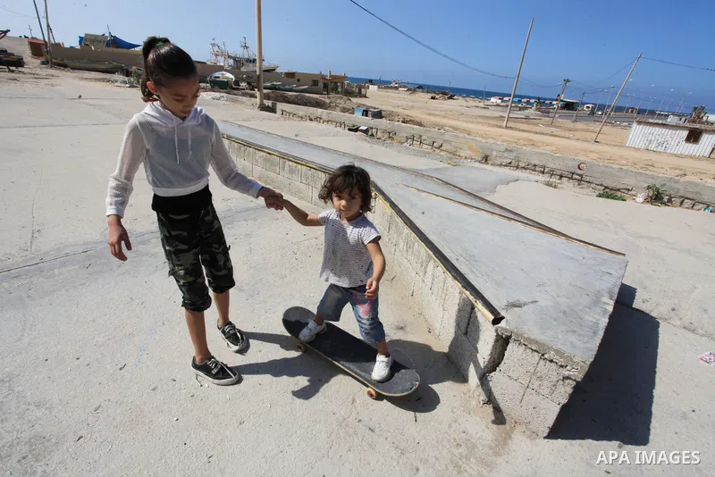 Palestinian girls practice on Skateboard sport at Gaza seaport, in Gaza city on October 27, 2021. A skateboard is a type of sports equipment used for skateboarding. They are usually made of a specially designed 7-8 ply m...