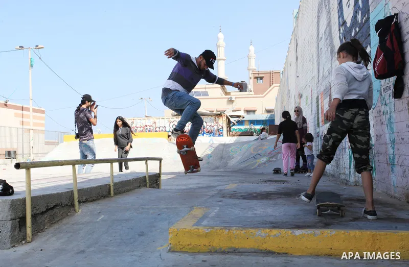 Palestinian girls practice on Skateboard sport at Gaza seaport, in Gaza city on October 27, 2021. A skateboard is a type of sports equipment used for skateboarding. They are usually made of a specially designed 7-8 ply m...