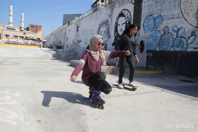 Palestinian girls practice on Skateboard sport at Gaza seaport, in Gaza city on October 27, 2021. A skateboard is a type of sports equipment used for skateboarding. They are usually made of a specially designed 7-8 ply m...