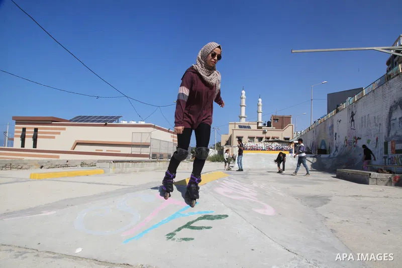 Palestinian girls practice on Skateboard sport at Gaza seaport, in Gaza city on October 27, 2021. A skateboard is a type of sports equipment used for skateboarding. They are usually made of a specially designed 7-8 ply m...