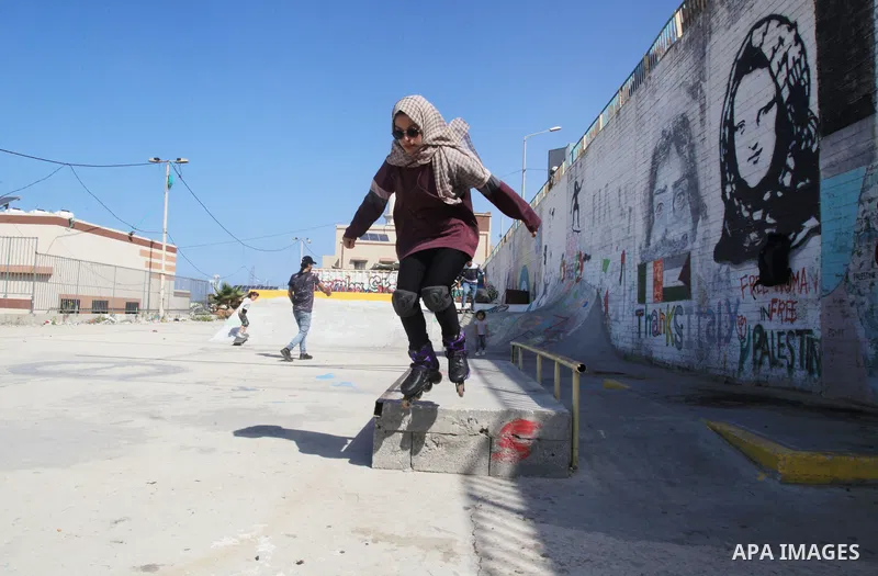 Palestinian girls practice on Skateboard sport at Gaza seaport, in Gaza city on October 27, 2021. A skateboard is a type of sports equipment used for skateboarding. They are usually made of a specially designed 7-8 ply m...