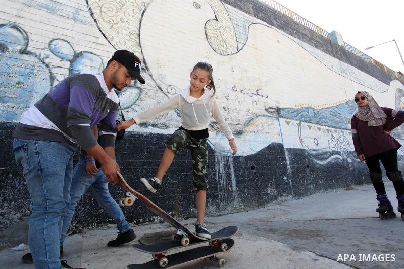 Palestinian girls practice on Skateboard sport at Gaza seaport, in Gaza city on October 27, 2021. A skateboard is a type of sports equipment used for skateboarding. They are usually made of a specially designed 7-8 ply m...