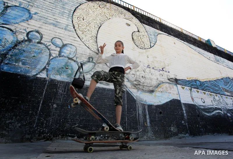 Palestinian girls practice on Skateboard sport at Gaza seaport, in Gaza city on October 27, 2021. A skateboard is a type of sports equipment used for skateboarding. They are usually made of a specially designed 7-8 ply m...
