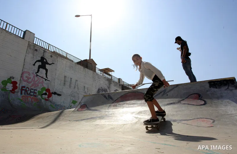 Palestinian girls practice on Skateboard sport at Gaza seaport, in Gaza city on October 27, 2021. A skateboard is a type of sports equipment used for skateboarding. They are usually made of a specially designed 7-8 ply m...