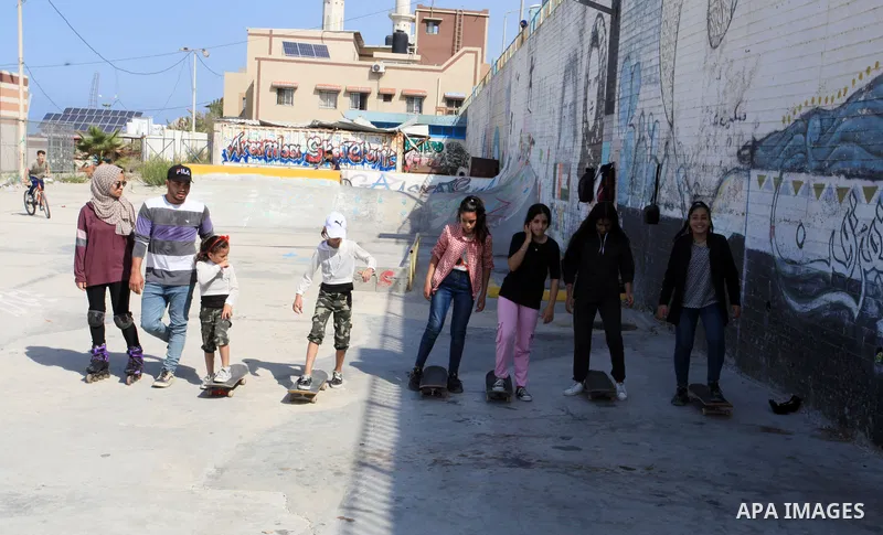 Palestinian girls practice on Skateboard sport at Gaza seaport, in Gaza city on October 27, 2021. A skateboard is a type of sports equipment used for skateboarding. They are usually made of a specially designed 7-8 ply m...