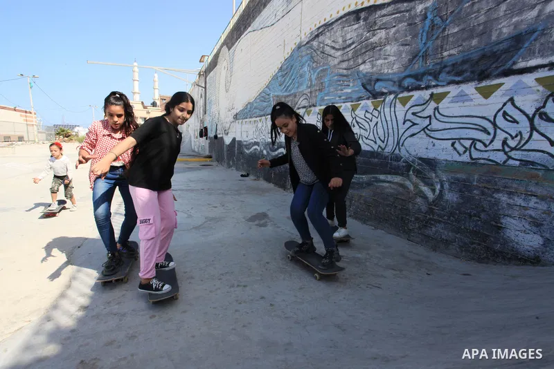 Palestinian girls practice on Skateboard sport at Gaza seaport, in Gaza city on October 27, 2021. A skateboard is a type of sports equipment used for skateboarding. They are usually made of a specially designed 7-8 ply m...