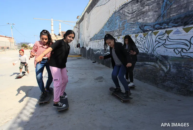 Palestinian girls practice on Skateboard sport at Gaza seaport, in Gaza city on October 27, 2021. A skateboard is a type of sports equipment used for skateboarding. They are usually made of a specially designed 7-8 ply m...