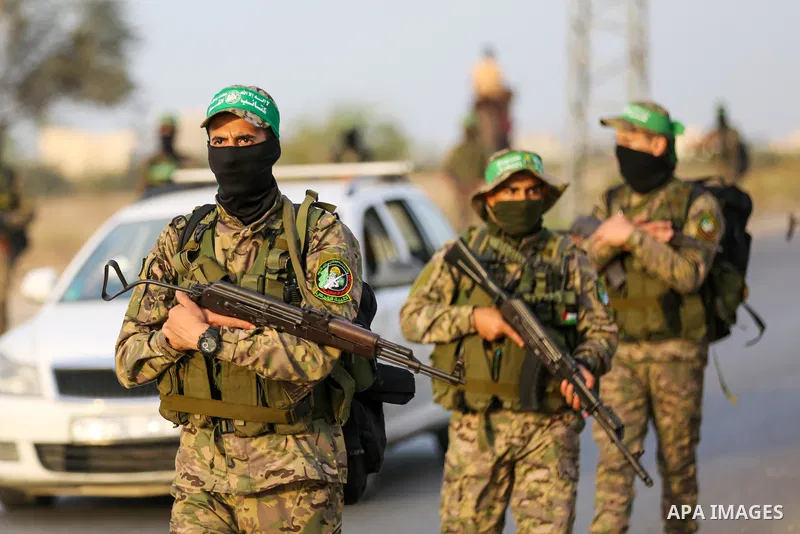 Masked militants from the Izzedine al-Qassam Brigades, a military wing of Hamas, march with their rifles along the main road of Nusseirat refugee camp, central Gaza Strip, in solidarity with Palestinian prisoners on hung...