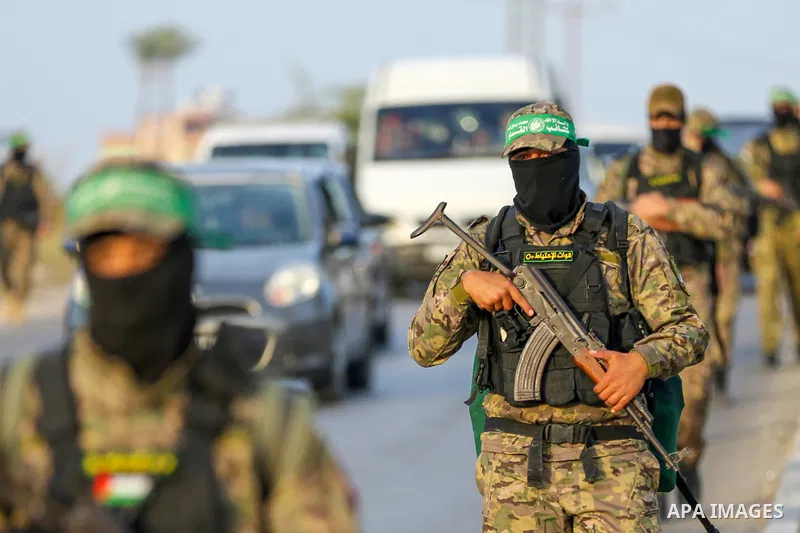 Masked militants from the Izzedine al-Qassam Brigades, a military wing of Hamas, march with their rifles along the main road of Nusseirat refugee camp, central Gaza Strip, in solidarity with Palestinian prisoners on hung...
