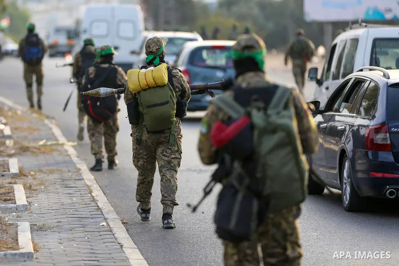 Masked militants from the Izzedine al-Qassam Brigades, a military wing of Hamas, march with their rifles along the main road of Nusseirat refugee camp, central Gaza Strip, in solidarity with Palestinian prisoners on hung...