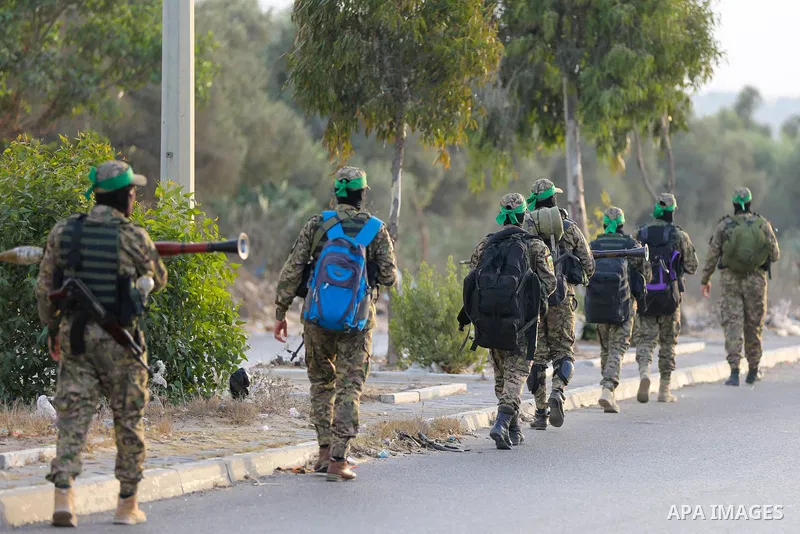 Masked militants from the Izzedine al-Qassam Brigades, a military wing of Hamas, march with their rifles along the main road of Nusseirat refugee camp, central Gaza Strip, in solidarity with Palestinian prisoners on hung...