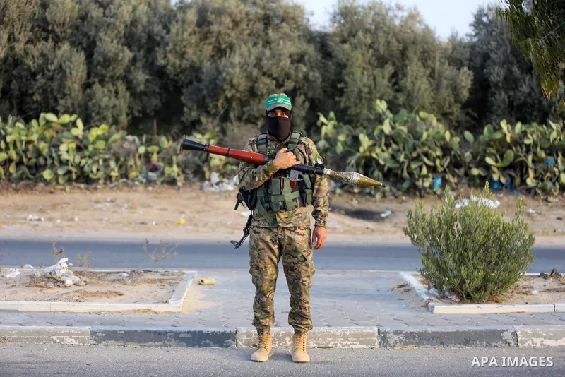 Masked militants from the Izzedine al-Qassam Brigades, a military wing of Hamas, march with their rifles along the main road of Nusseirat refugee camp, central Gaza Strip, in solidarity with Palestinian prisoners on hung...