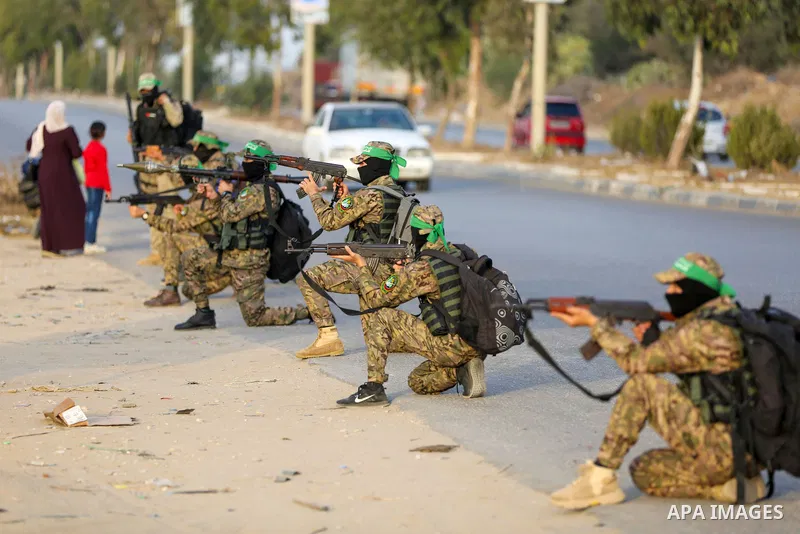 Masked militants from the Izzedine al-Qassam Brigades, a military wing of Hamas, march with their rifles along the main road of Nusseirat refugee camp, central Gaza Strip, in solidarity with Palestinian prisoners on hung...