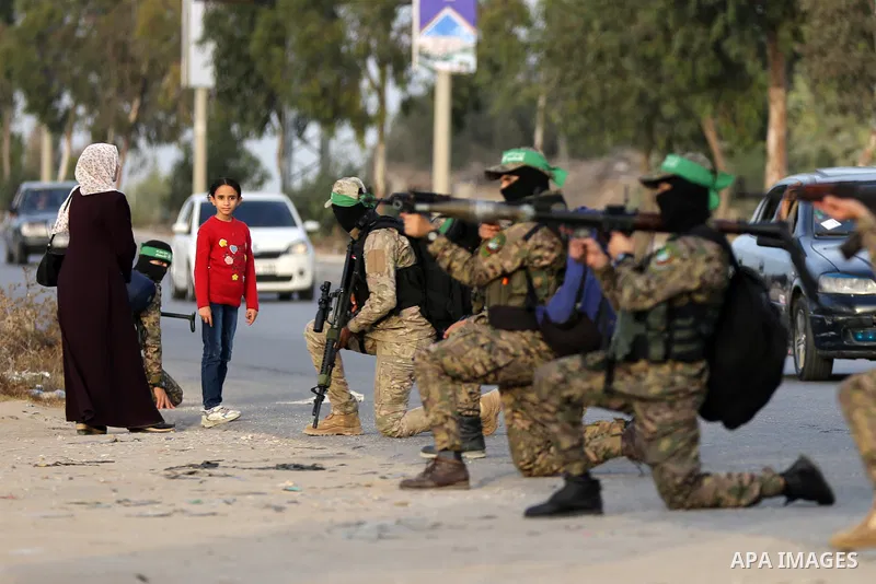 Masked militants from the Izzedine al-Qassam Brigades, a military wing of Hamas, march with their rifles along the main road of Nusseirat refugee camp, central Gaza Strip, in solidarity with Palestinian prisoners on hung...