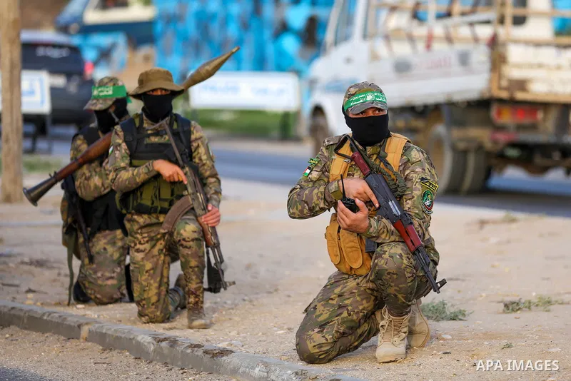 Masked militants from the Izzedine al-Qassam Brigades, a military wing of Hamas, march with their rifles along the main road of Nusseirat refugee camp, central Gaza Strip, in solidarity with Palestinian prisoners on hung...