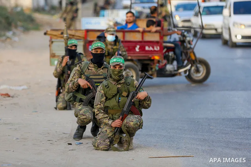 Masked militants from the Izzedine al-Qassam Brigades, a military wing of Hamas, march with their rifles along the main road of Nusseirat refugee camp, central Gaza Strip, in solidarity with Palestinian prisoners on hung...