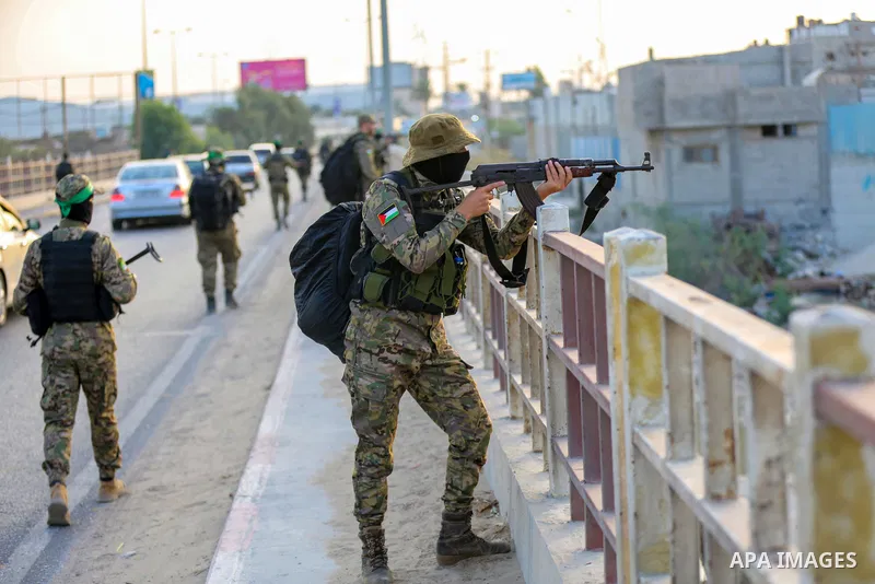 Masked militants from the Izzedine al-Qassam Brigades, a military wing of Hamas, march with their rifles along the main road of Nusseirat refugee camp, central Gaza Strip, in solidarity with Palestinian prisoners on hung...