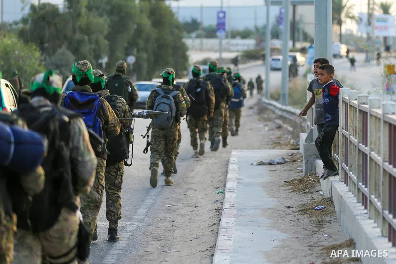 Masked militants from the Izzedine al-Qassam Brigades, a military wing of Hamas, march with their rifles along the main road of Nusseirat refugee camp, central Gaza Strip, in solidarity with Palestinian prisoners on hung...