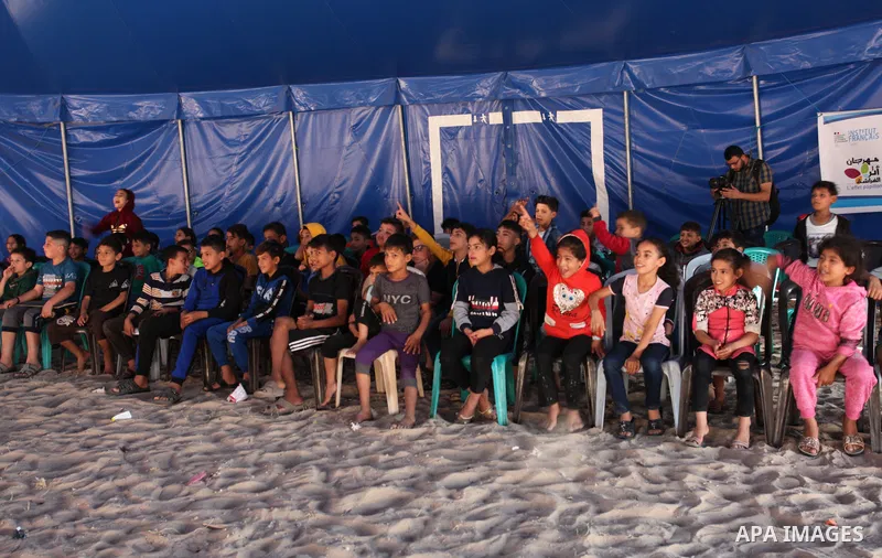 Palestinian children attend a circus performance inside a circus tent, in Beit Hanoun in the nothern Gaza Strip on October 28, 2021. The Gaza Stars School was established in an area of one dunam (1,000 square metres) and...