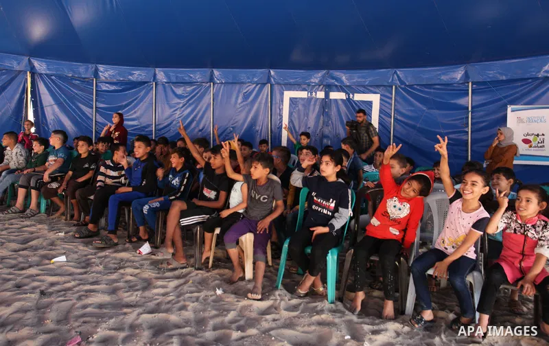 Palestinian children attend a circus performance inside a circus tent, in Beit Hanoun in the nothern Gaza Strip on October 28, 2021. The Gaza Stars School was established in an area of one dunam (1,000 square metres) and...