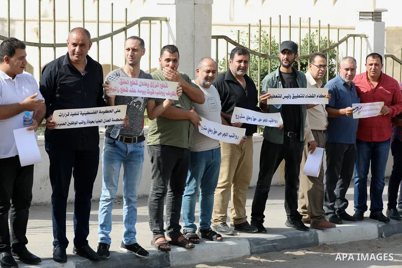 Employees of the Palestinian Authority whose salaries have been cut participate in a protest to demand the return of their salaries in front of the European Union headquarters in Gaza city on October 28, 2021. Photo by R...