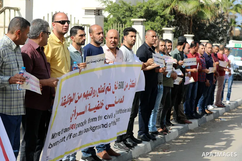 Employees of the Palestinian Authority whose salaries have been cut participate in a protest to demand the return of their salaries in front of the European Union headquarters in Gaza city on October 28, 2021. Photo by R...