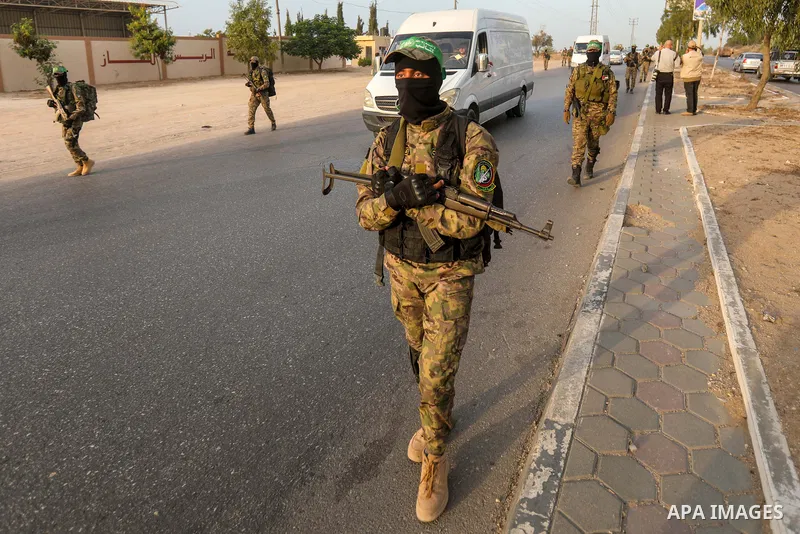 Masked militants from the Izzedine al-Qassam Brigades, a military wing of Hamas, march with their rifles along the main road of Nusseirat refugee camp, central Gaza Strip, in solidarity with Palestinian prisoners on hung...