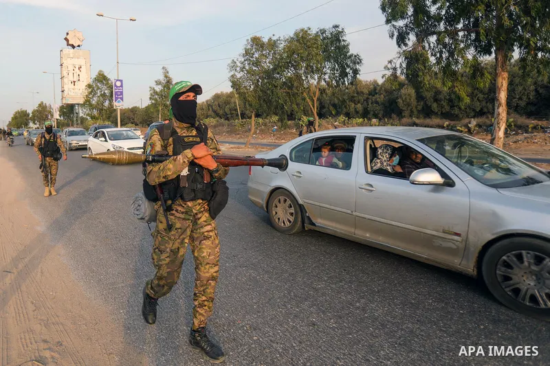 Masked militants from the Izzedine al-Qassam Brigades, a military wing of Hamas, march with their rifles along the main road of Nusseirat refugee camp, central Gaza Strip, in solidarity with Palestinian prisoners on hung...