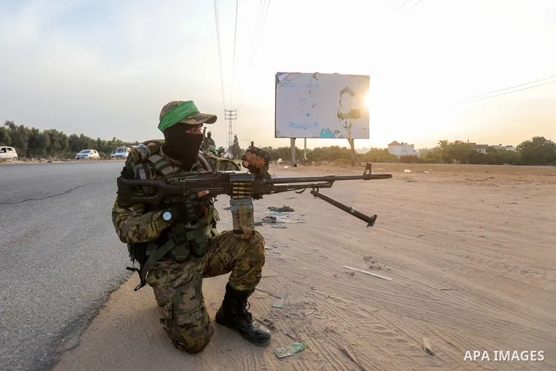 Masked militants from the Izzedine al-Qassam Brigades, a military wing of Hamas, march with their rifles along the main road of Nusseirat refugee camp, central Gaza Strip, in solidarity with Palestinian prisoners on hung...