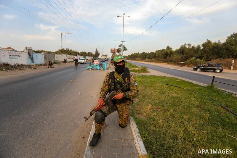 Masked militants from the Izzedine al-Qassam Brigades, a military wing of Hamas, march with their rifles along the main road of Nusseirat refugee camp, central Gaza Strip, in solidarity with Palestinian prisoners on hung...