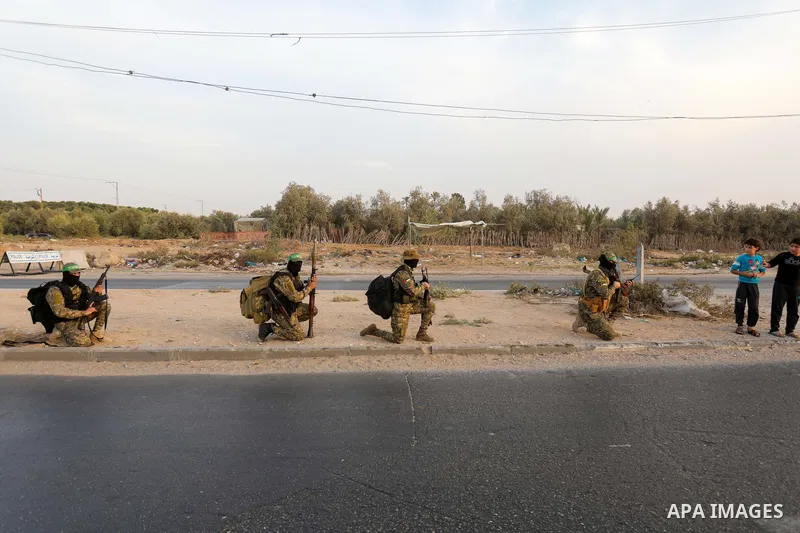 Masked militants from the Izzedine al-Qassam Brigades, a military wing of Hamas, march with their rifles along the main road of Nusseirat refugee camp, central Gaza Strip, in solidarity with Palestinian prisoners on hung...