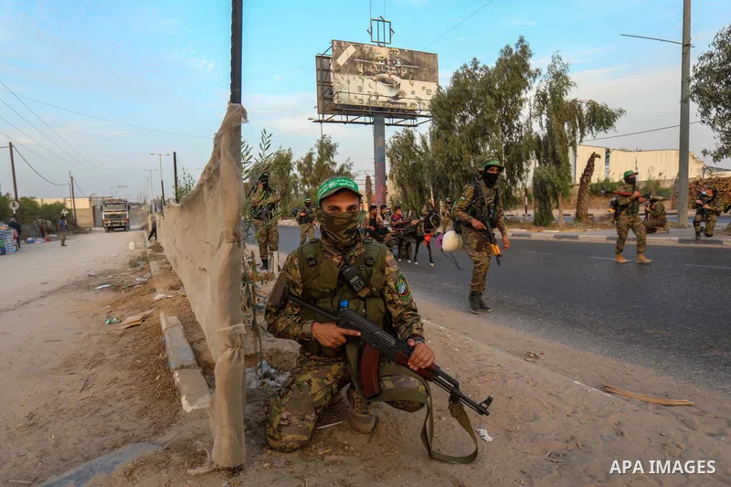 Masked militants from the Izzedine al-Qassam Brigades, a military wing of Hamas, march with their rifles along the main road of Nusseirat refugee camp, central Gaza Strip, in solidarity with Palestinian prisoners on hung...