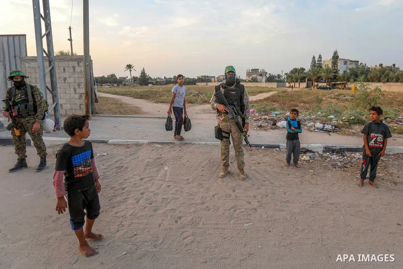 Masked militants from the Izzedine al-Qassam Brigades, a military wing of Hamas, march with their rifles along the main road of Nusseirat refugee camp, central Gaza Strip, in solidarity with Palestinian prisoners on hung...