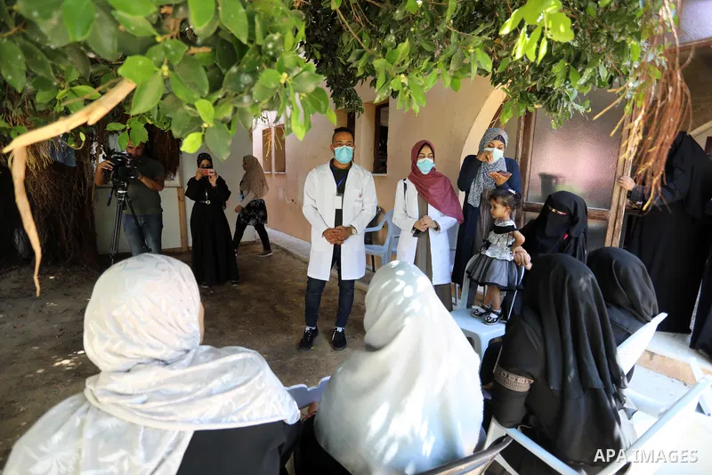Palestinian medicals and activists participate during the "Awareness Bus" initiative to educate people about the Corona vaccine in poor areas, in Beit Lahia in the northern of Gaza Strip on September 2, 2021. Photo by As...