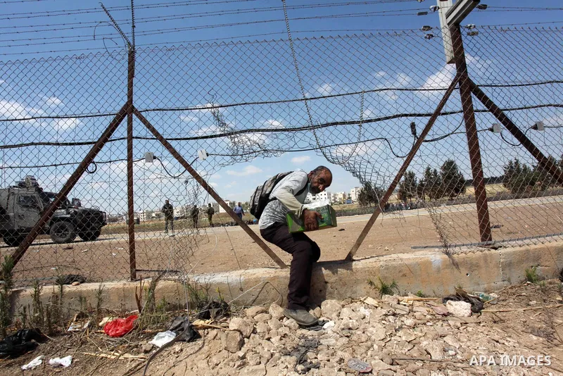 A Palestinian labourer crosses through a hole in a security fence in the West Bank town of Jenin, on September 6, 2021, following the break out of six Palestinians from an Israeli prison. - Six Palestinians broke out of...