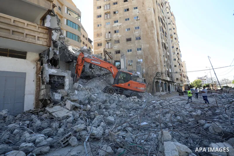 Palestinian workers use a bulldozer to remove the rubbles of a building which was hit by Israeli strikes during the recent 11-day conflict between Israel and Hamas on May, in Gaza city on September 19, 2021. The Undersec...