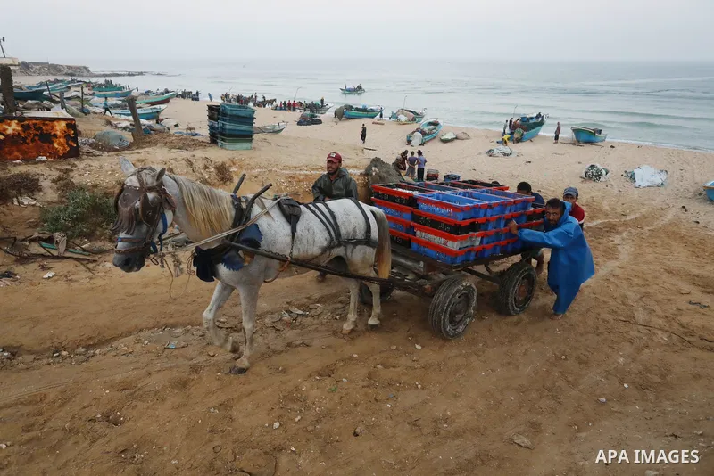 Palestinian fishermen work on the shore of the Mediterranean Sea, in Deir El-Balah, in the center of Gaza strip, on September 21, 2021. Fishing is a major source of revenue for the impoverished Palestinian enclave. Israe...