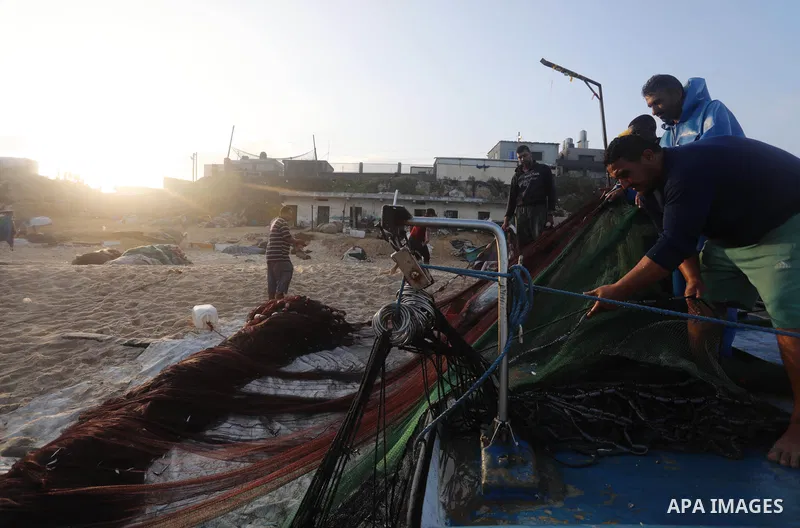 Palestinian fishermen work on the shore of the Mediterranean Sea, in Deir El-Balah, in the center of Gaza strip, on September 21, 2021. Fishing is a major source of revenue for the impoverished Palestinian enclave. Israe...