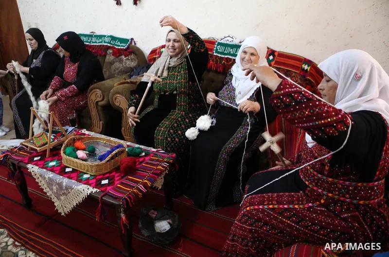 Palestinian women weave the traditional products, wool ornaments and carpets in the West Bank city of Hebron on September 23, 2021. Weaving sheep's wool into traditional carpets is one oldest professions, it takes skill,...