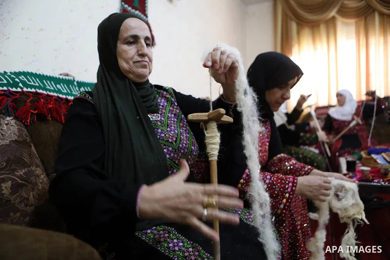 Palestinian women weave the traditional products, wool ornaments and carpets in the West Bank city of Hebron on September 23, 2021. Weaving sheep's wool into traditional carpets is one oldest professions, it takes skill,...