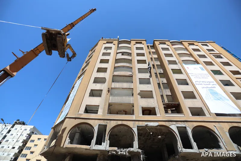 Palestinian workers use a bulldozer to remove the rubbles of al-Jawhara tower which was hit by Israeli strikes during the recent 11-day conflict between Israel and Hamas on May, in Gaza city on September 26, 2021. The to...