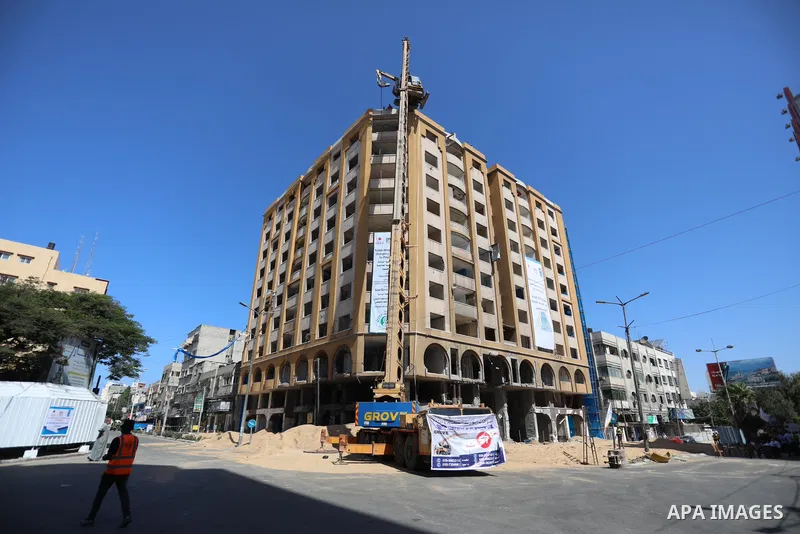 Palestinian workers use a bulldozer to remove the rubbles of al-Jawhara tower which was hit by Israeli strikes during the recent 11-day conflict between Israel and Hamas on May, in Gaza city on September 26, 2021. The to...