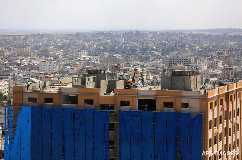 Palestinian workers use a bulldozer to remove the rubbles of al-Jawhara tower which was hit by Israeli strikes during the recent 11-day conflict between Israel and Hamas on May, in Gaza city on September 27, 2021. The to...