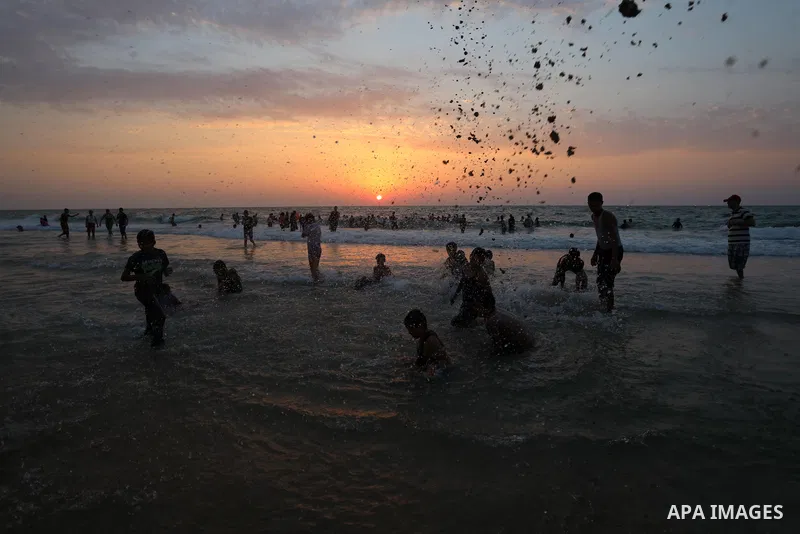 Palestinians gather at the beach in the Mediterranean Sea in Deir al-Balah in the center of Gaza Strip on August 27, 2021. The beach is one of the few open public spaces in this densely populated city. Photo by Ashraf Am...