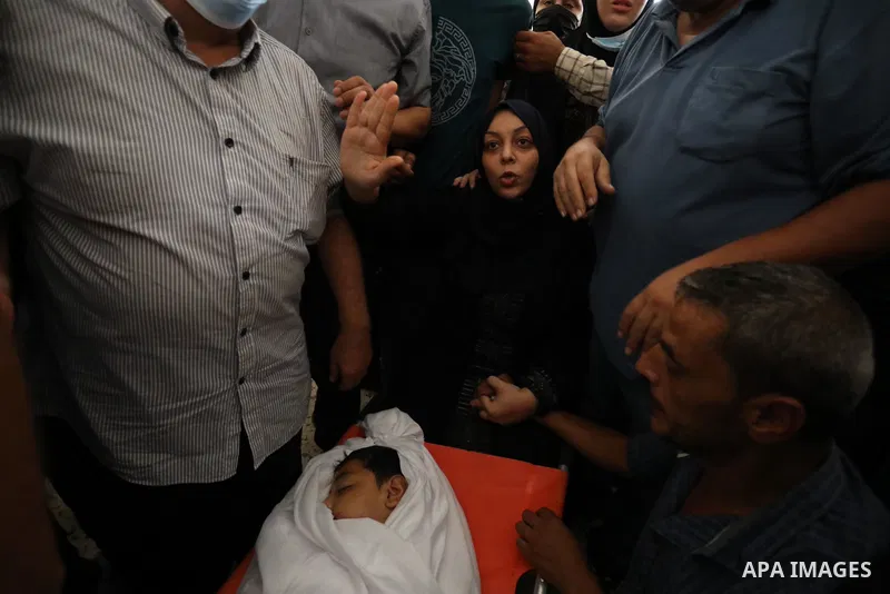 The mother of Palestinian teen Omar Abu Neal, 12, mourns over his body during his funeral in Gaza city on August 28, 2021. Abu Neal is the second Palestinian to die of wounds sustained during the same activity held marki...