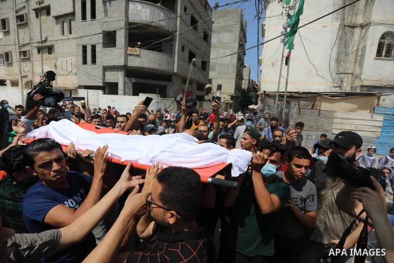 Palestinian mourners carry the body of teen Omar Abu al-Neal, who died of a wound he sustained during an anti-Israel protest at the Israel-Gaza border fence last week, during his funeral in Gaza city on August 28, 2021....