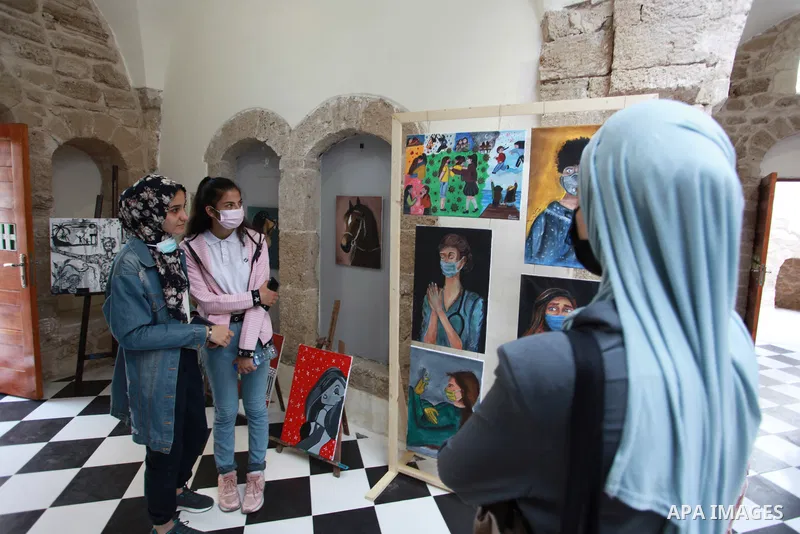 Palestinians attend an art exhibition "We Love Life" organized by Al-Qattan Cultural Center, at archaeological al-Ghussein house in Gaza city on August 29, 2021. The exhibition includes paintings by children that they dr...