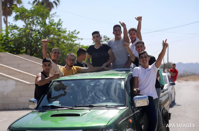 Palestinian high school students celebrate on the street after passing their final exams known as "Tawjihi", in the West Bank city of of Ramallah, on August 3, 2021. Photo by Ibrahim Atta